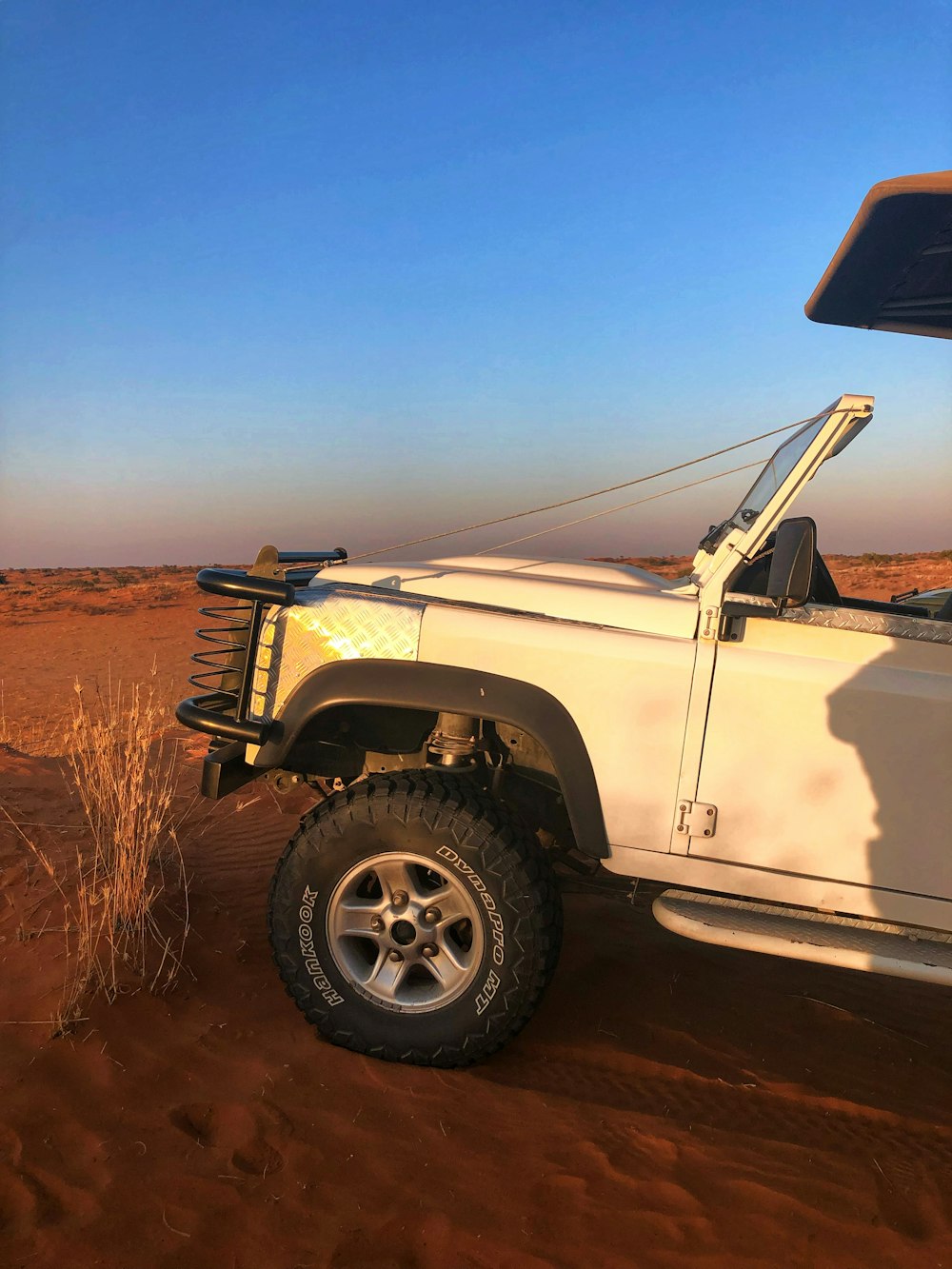 a white truck parked on top of a dirt field