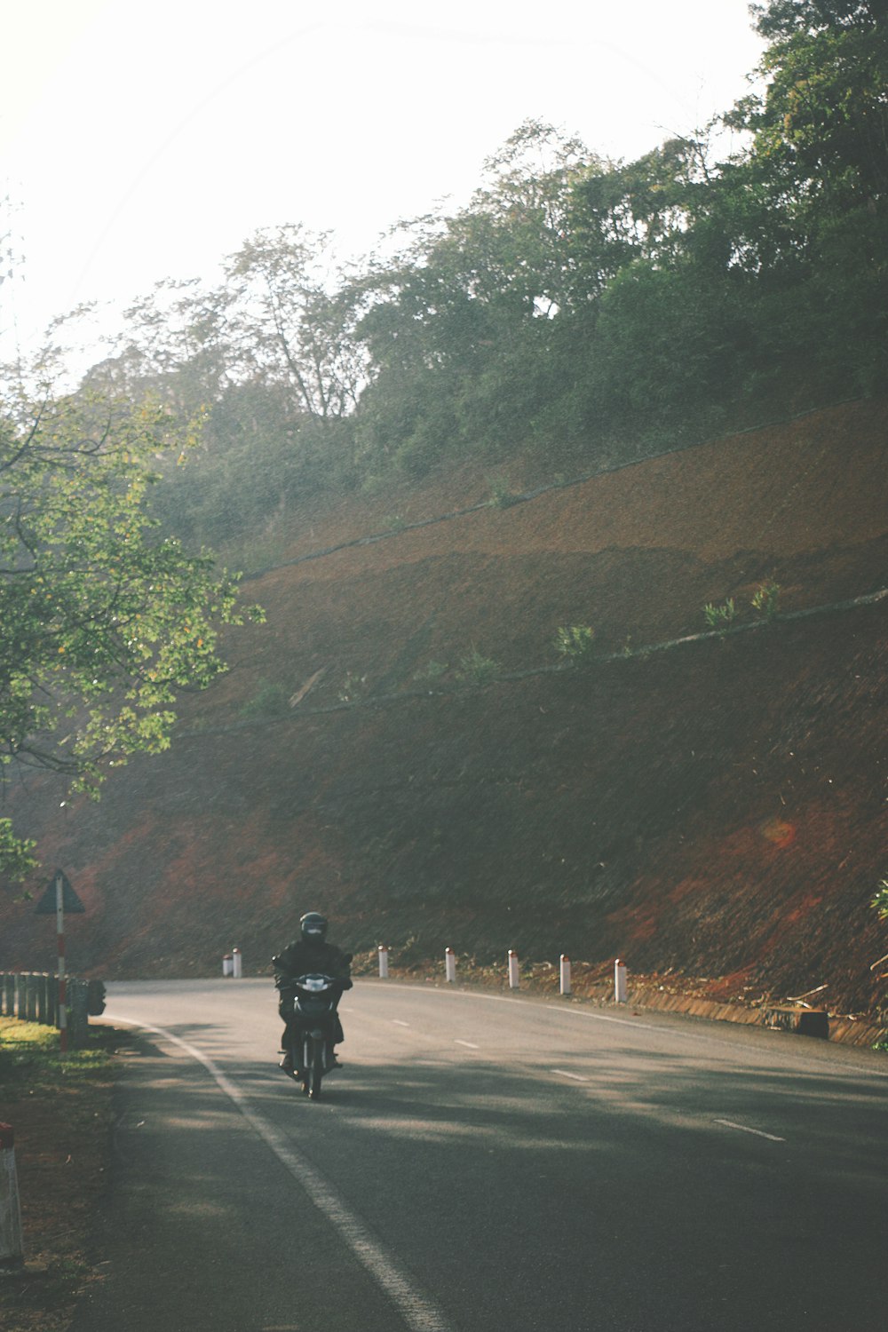 a man riding a motorcycle down a curvy road