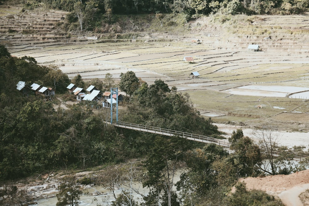 an aerial view of a field with a bridge