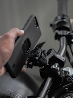 a person holding a cell phone near a bike