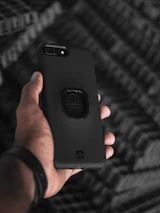 Hands holding a smartphone with a stylish protective case, showcasing detail and quality.