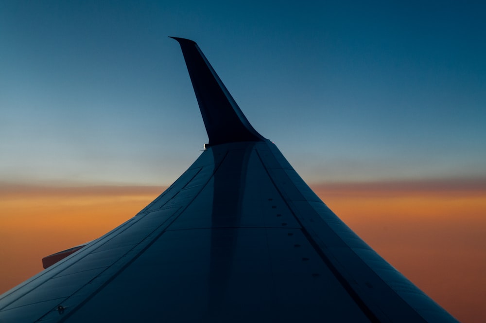 the wing of an airplane as the sun sets