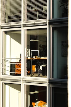 A tidy modern office with sunlight streaming through clean windows and polished desks.