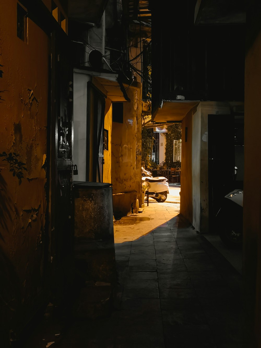 a dark alley with a bench and a fire hydrant