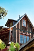 a house with a metal roof and a tree