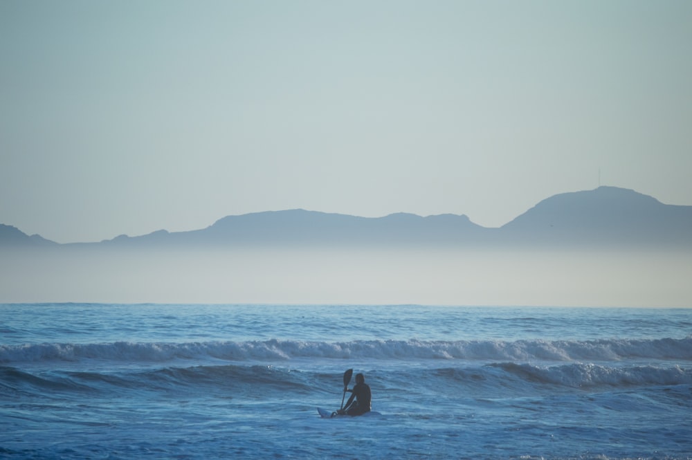 Un paio di persone in piedi sulla cima di un'onda nell'oceano