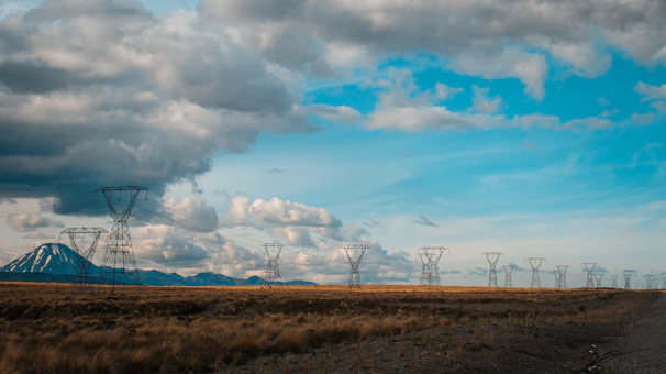 Aerial shot of a vast network of electrical transmission towers stretching across the landscape.