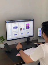 a man sitting at a desk in front of a computer