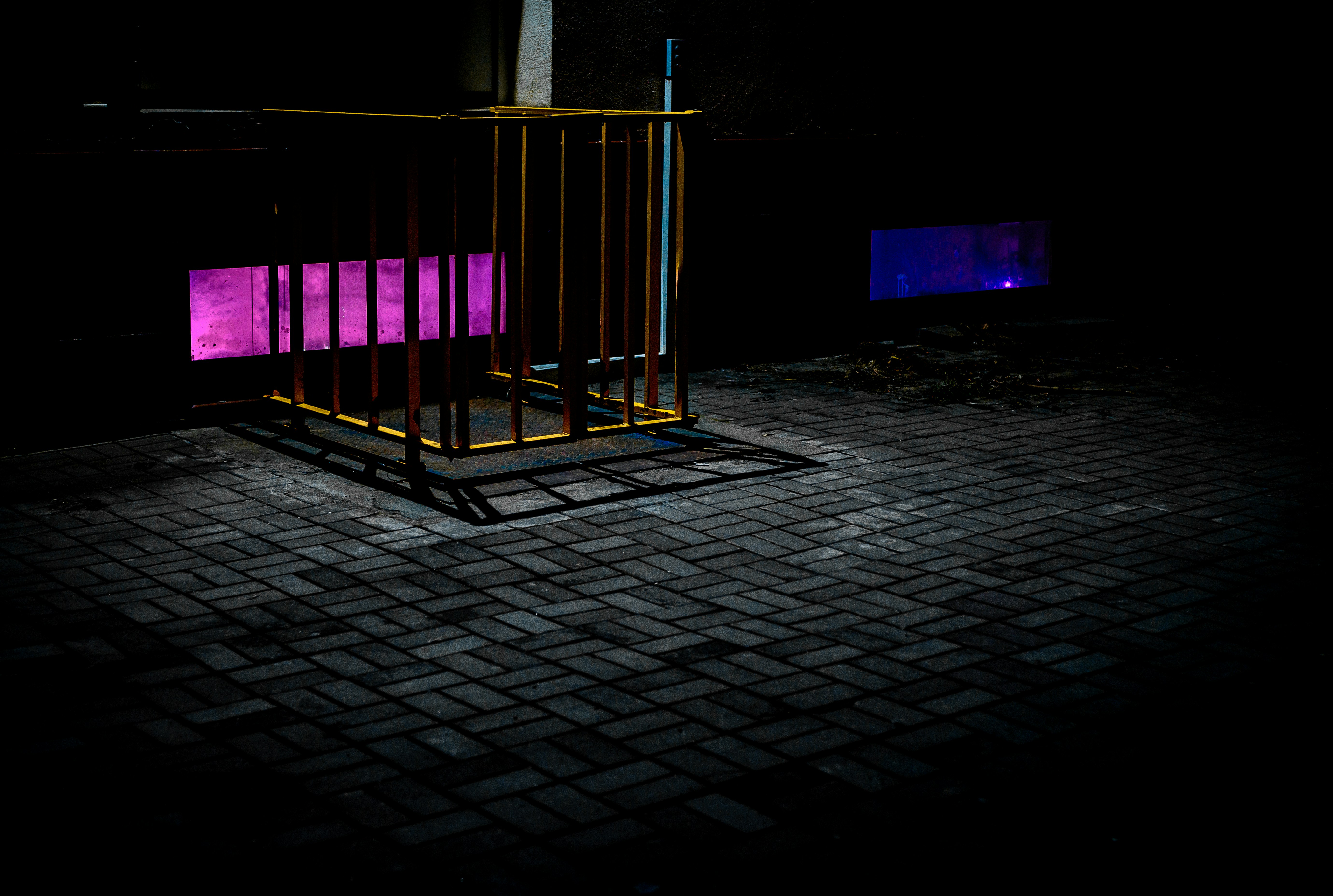 a gate with a purple light on it in the dark