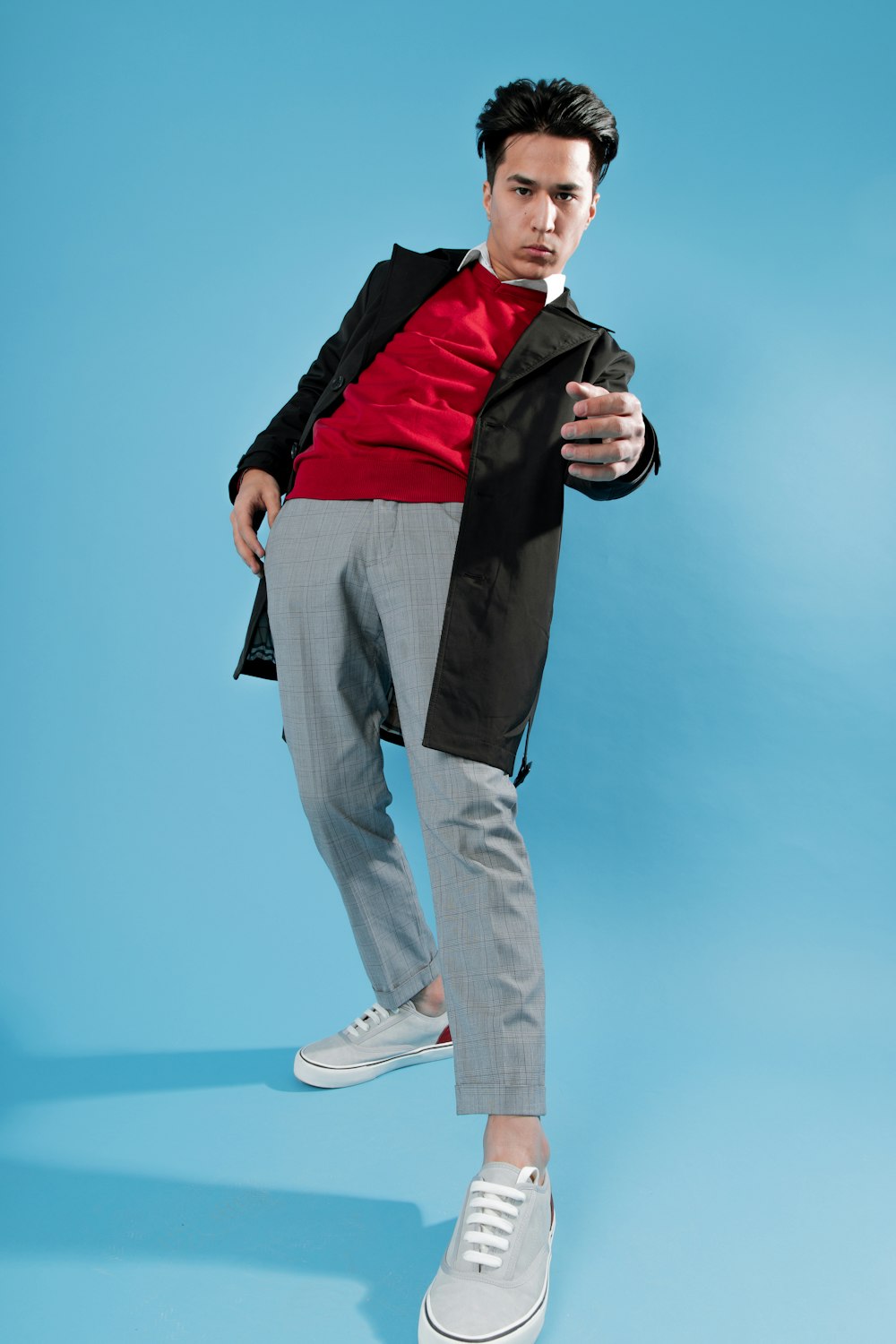 a man in a red shirt and grey pants