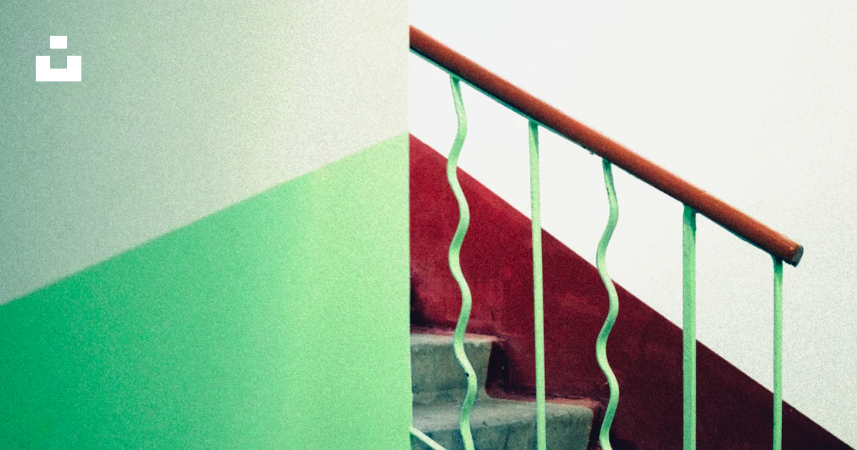 A staircase with a red hand rail and green handrail photo – Free ...