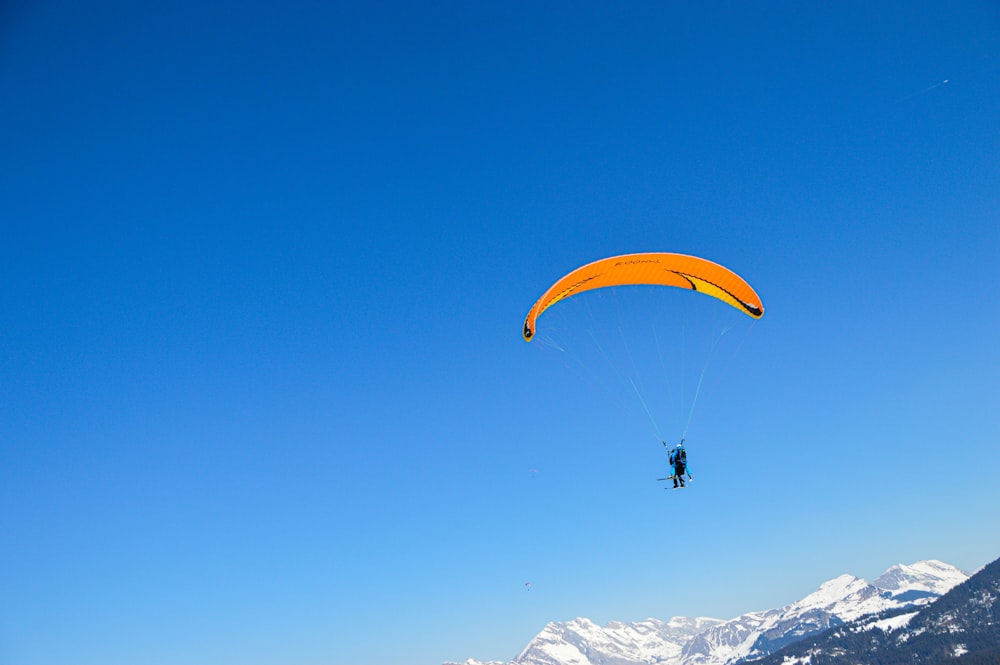 a person is parasailing over a mountain range