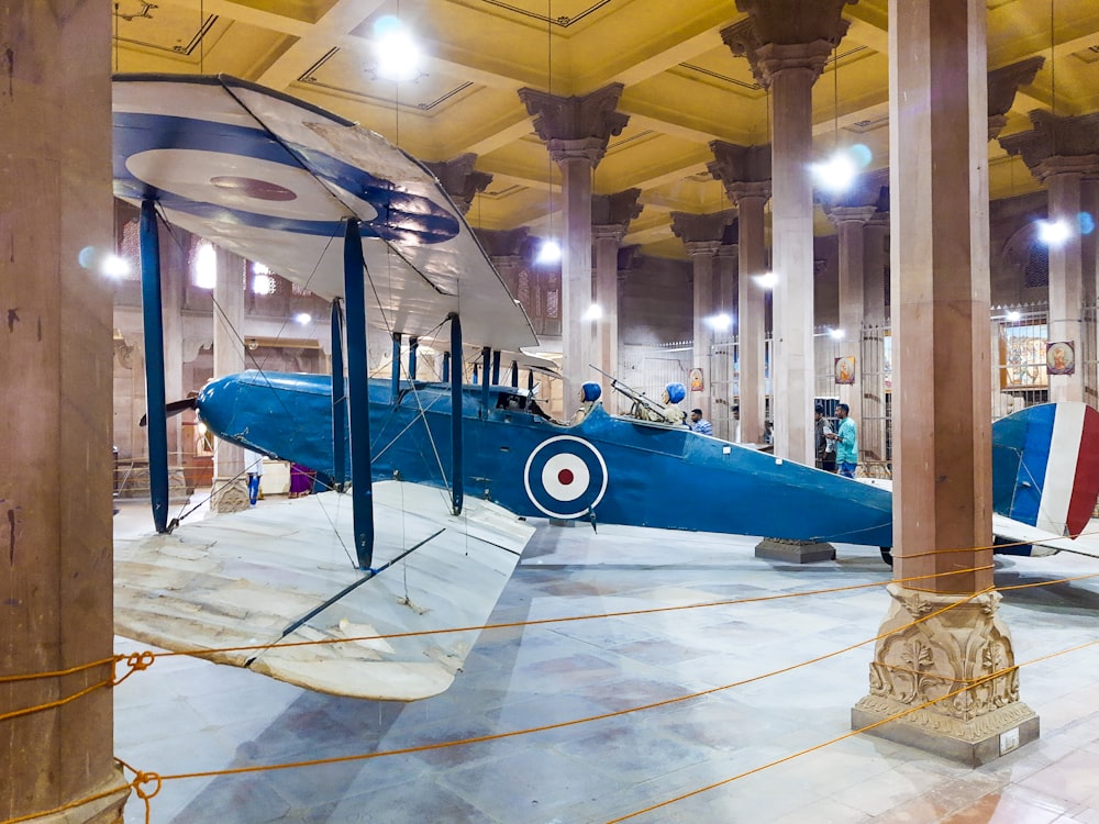 a blue airplane is on display in a museum