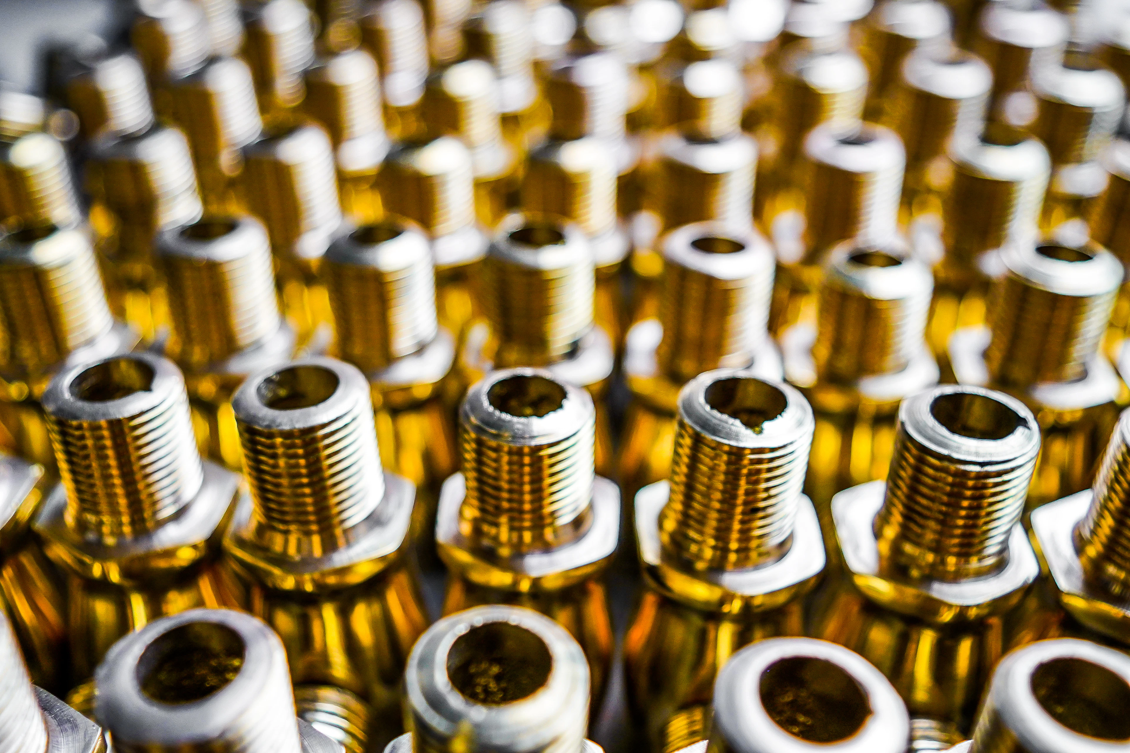 Rows of brass threaded fittings and nuts