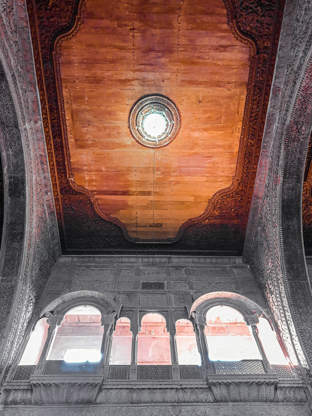 the ceiling of a building with a circular window