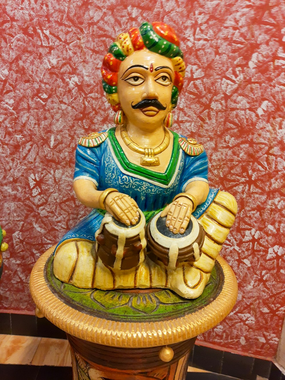 a statue of a man sitting on top of a table