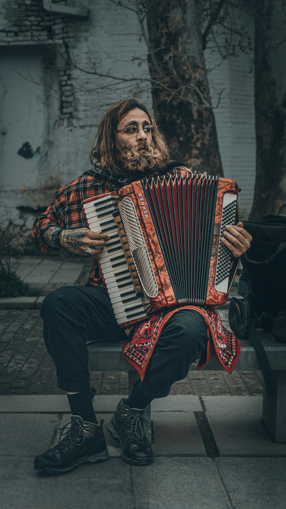 a man sitting on a bench holding an accordion
