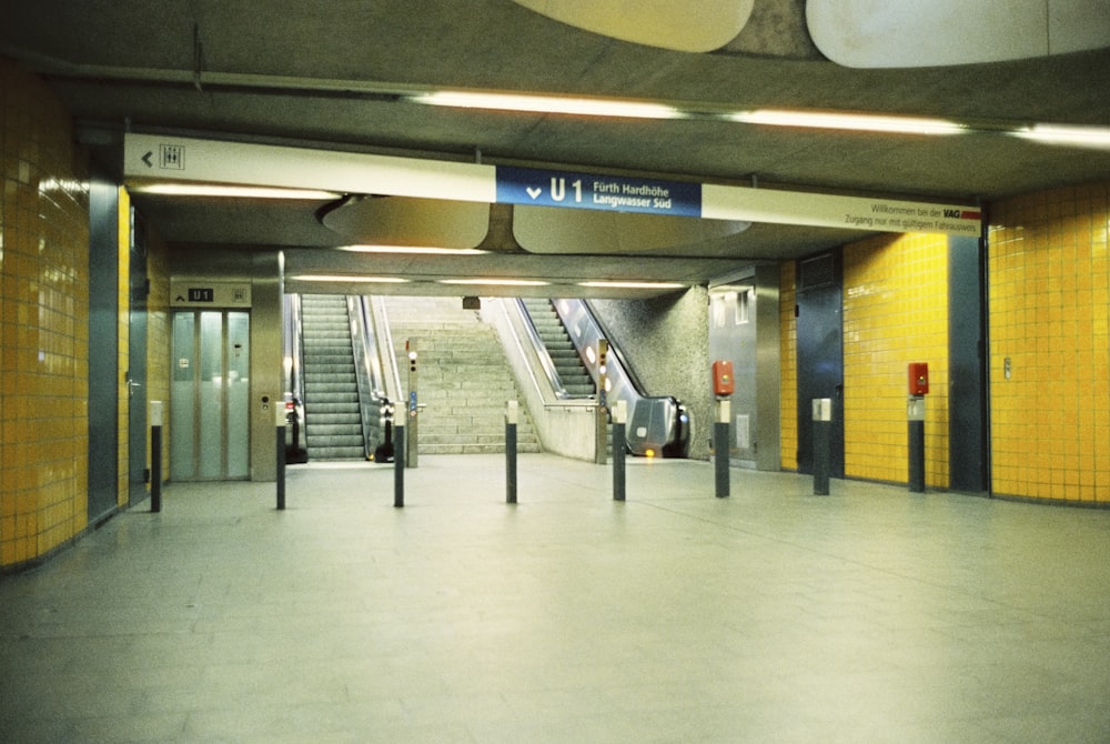 an empty subway station with yellow and blue walls