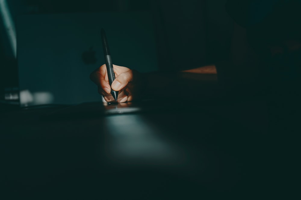 a person writing on a piece of paper with a pen