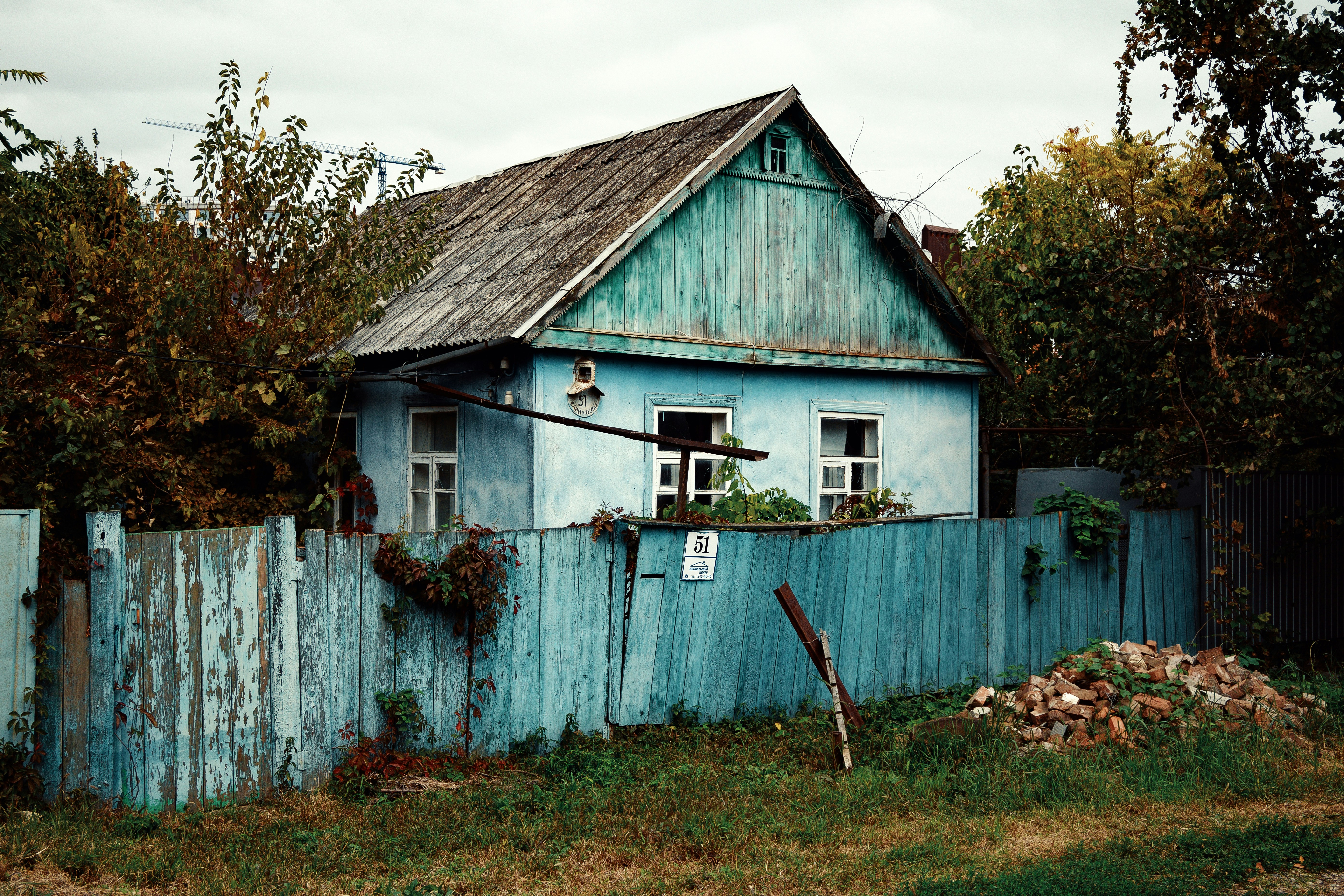 a blue house with a wooden fence around it