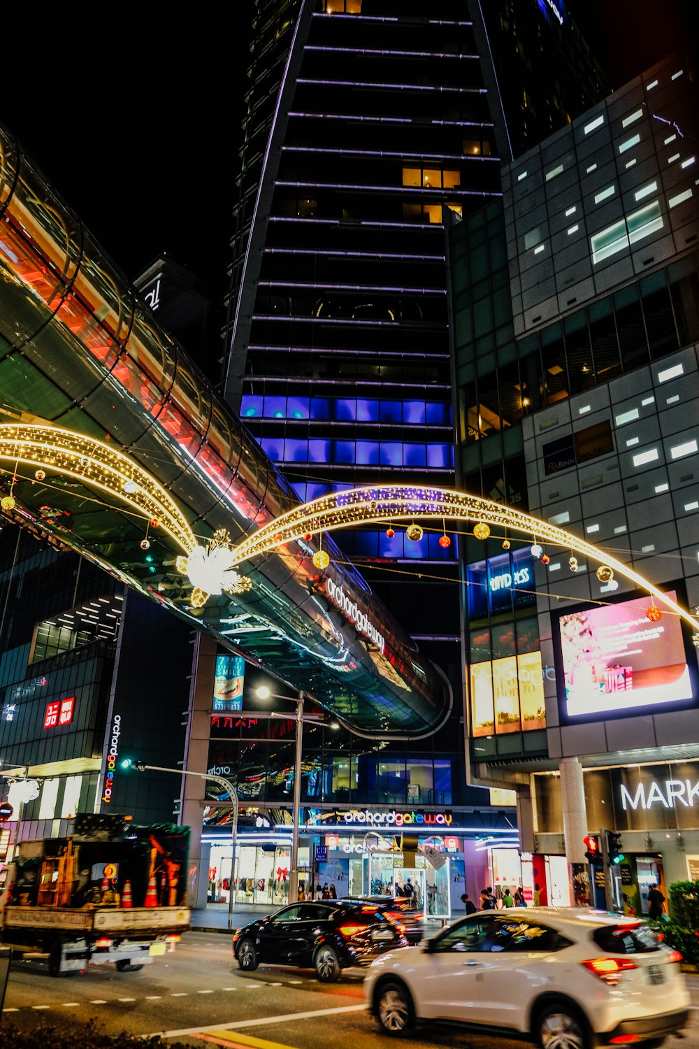 a busy city street at night with a tall building in the background