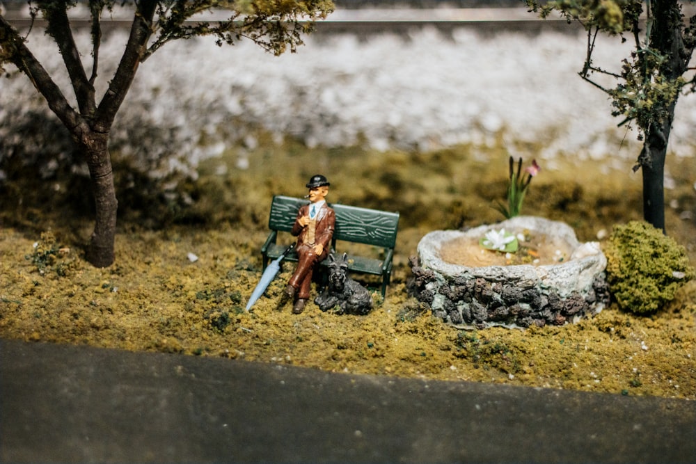 a miniature statue of a man sitting on a bench