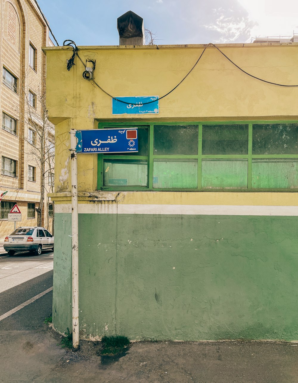 a green and yellow building with a sign on it