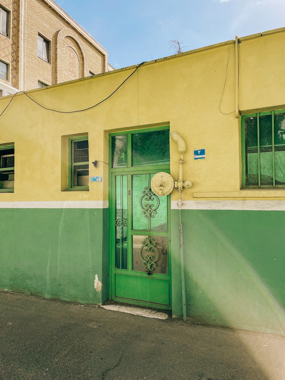 a yellow building with a green door and window