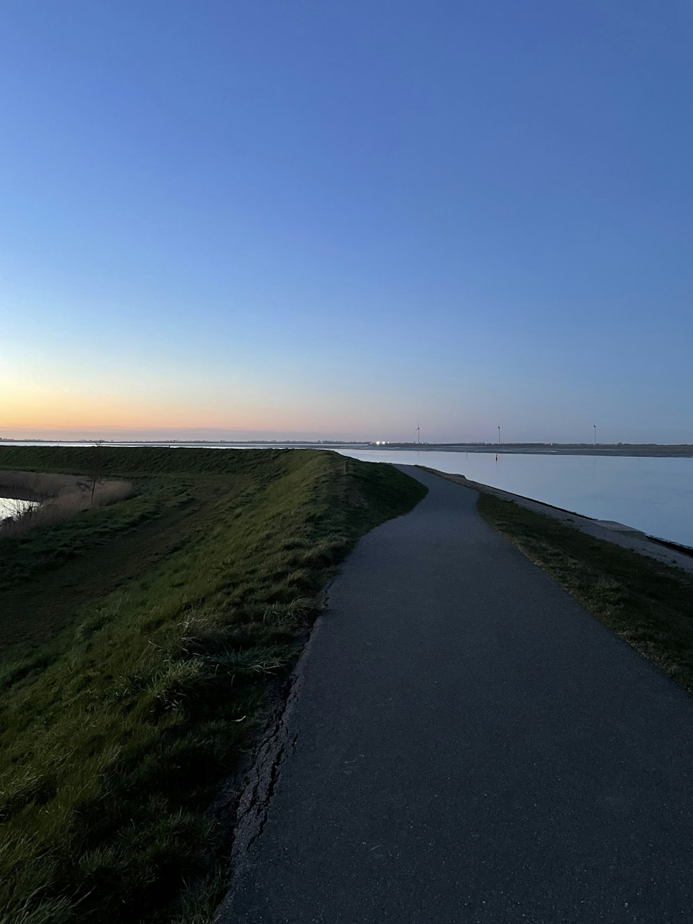 a paved path next to a body of water