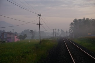 A misty morning scene of a quaint village seen from a train window.