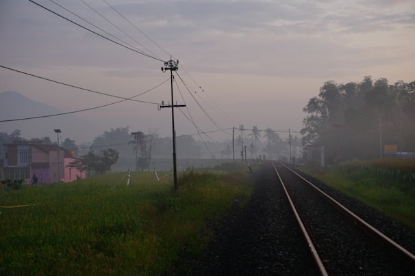 A misty morning scene of a quaint village seen from a train window.