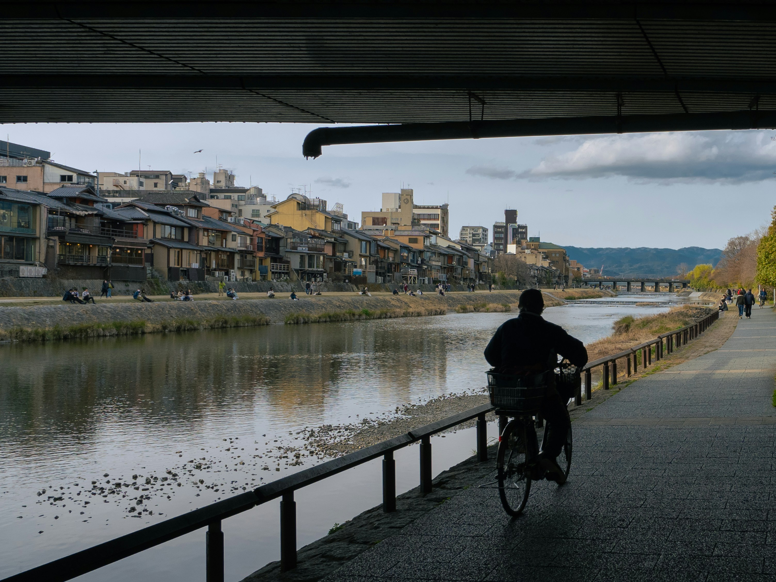 A man riding a bike down a street next to a river