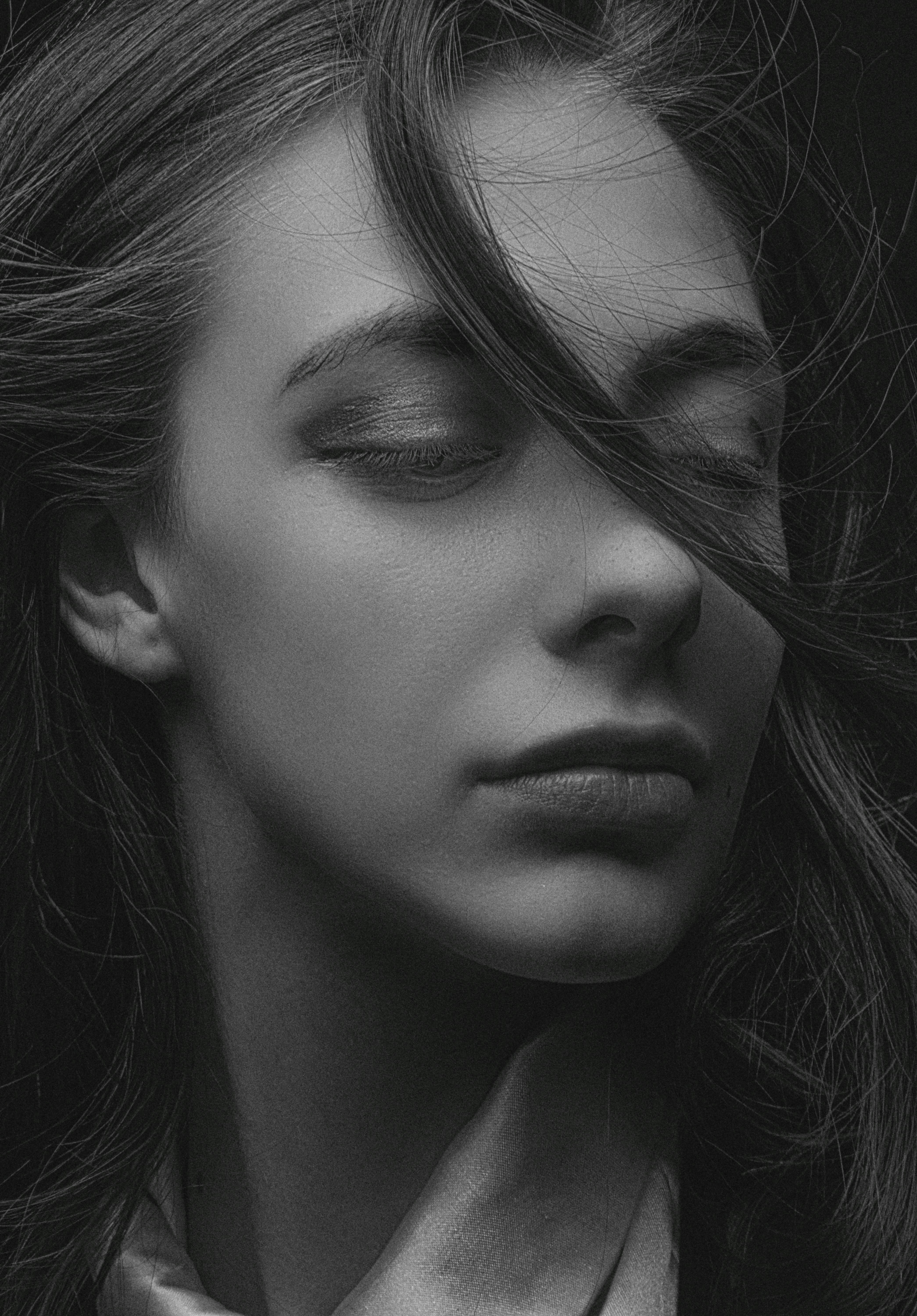 a black and white photo of a woman with her eyes closed