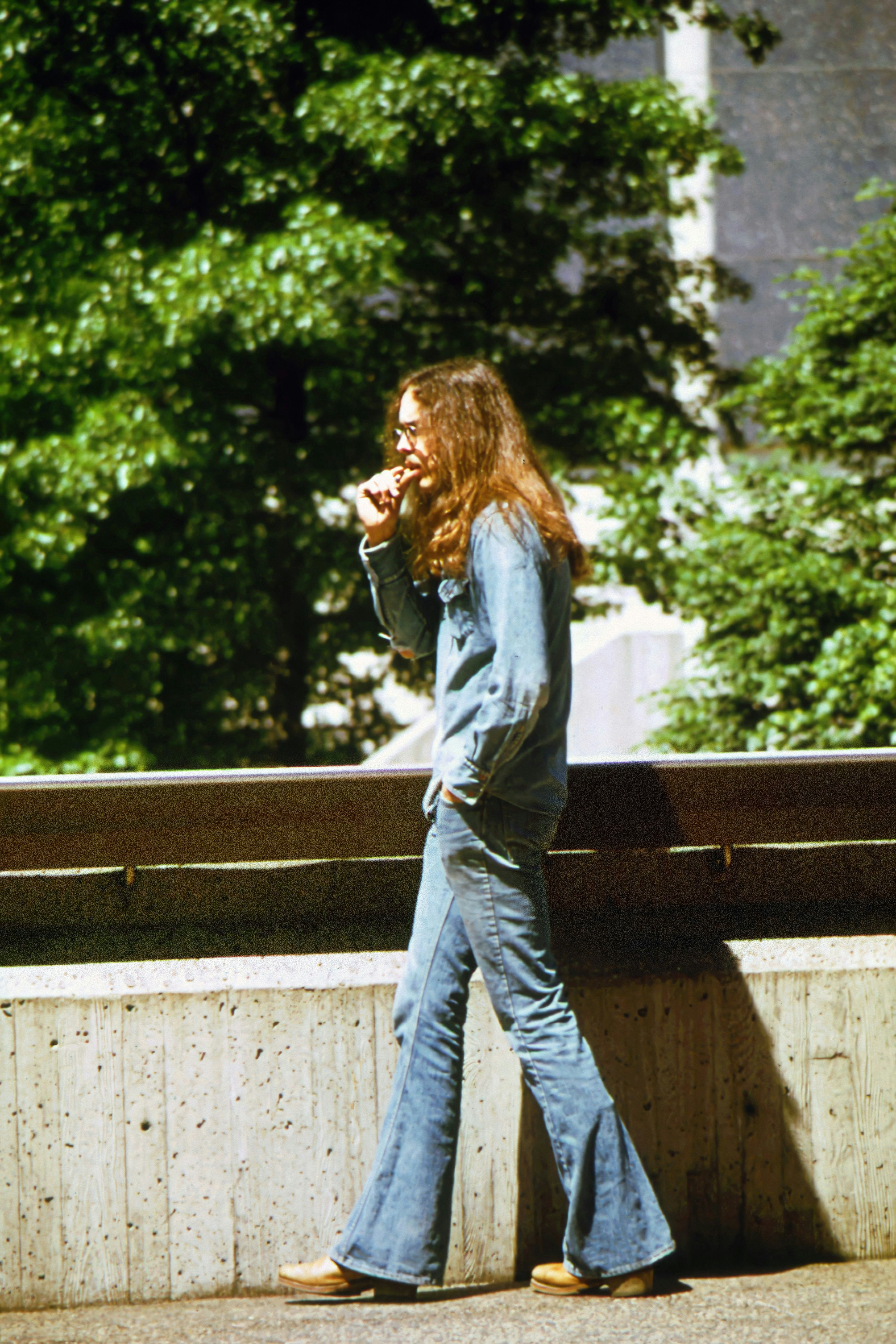 Une femme aux cheveux longs marchant sur un trottoir