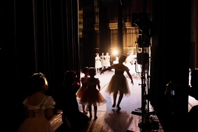 A vibrant backstage scene with artists preparing under glowing lights.