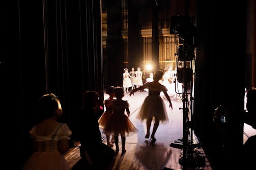A group of dancers laughing together backstage, sharing a moment of camaraderie.