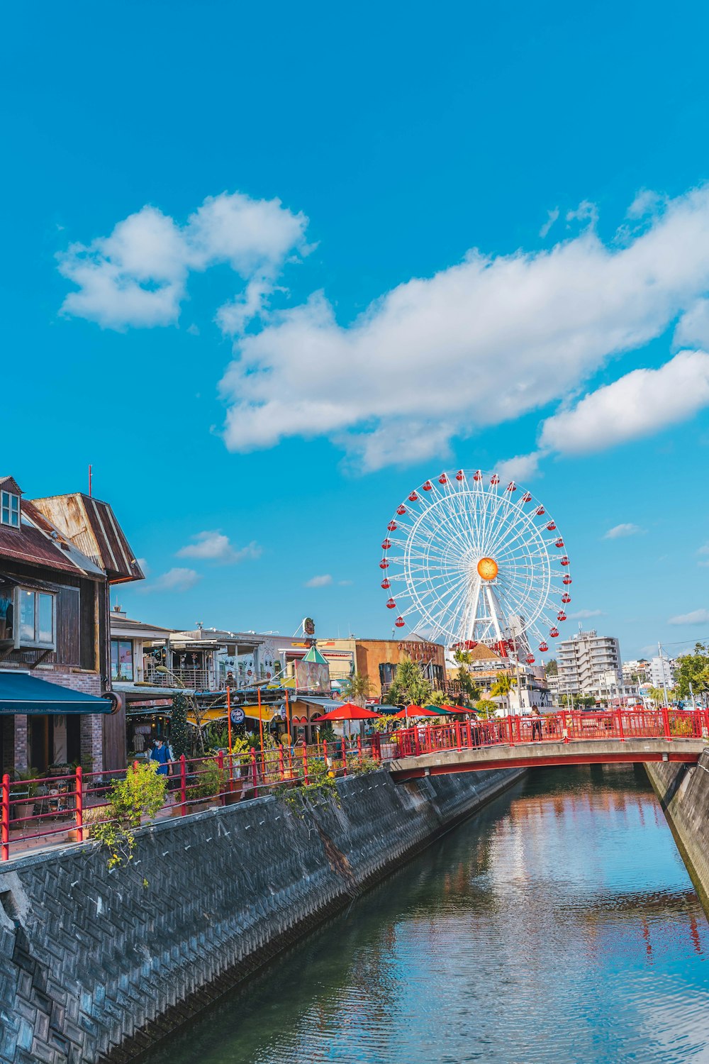 une grande roue sur un pont au-dessus d’un plan d’eau