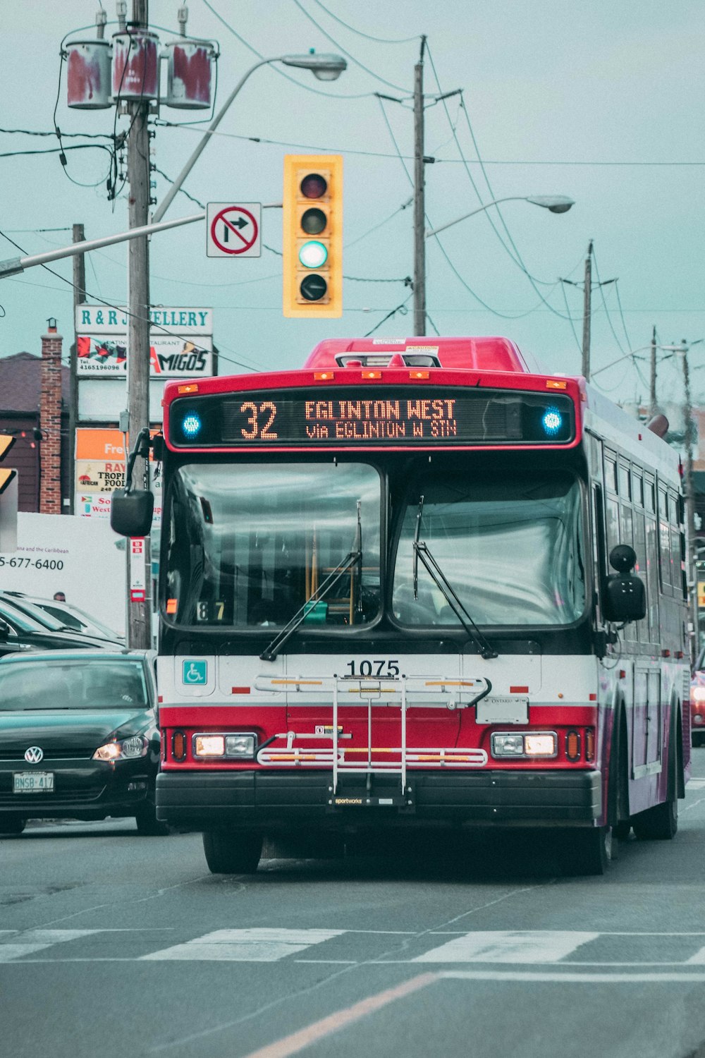 a red and white bus driving down a street