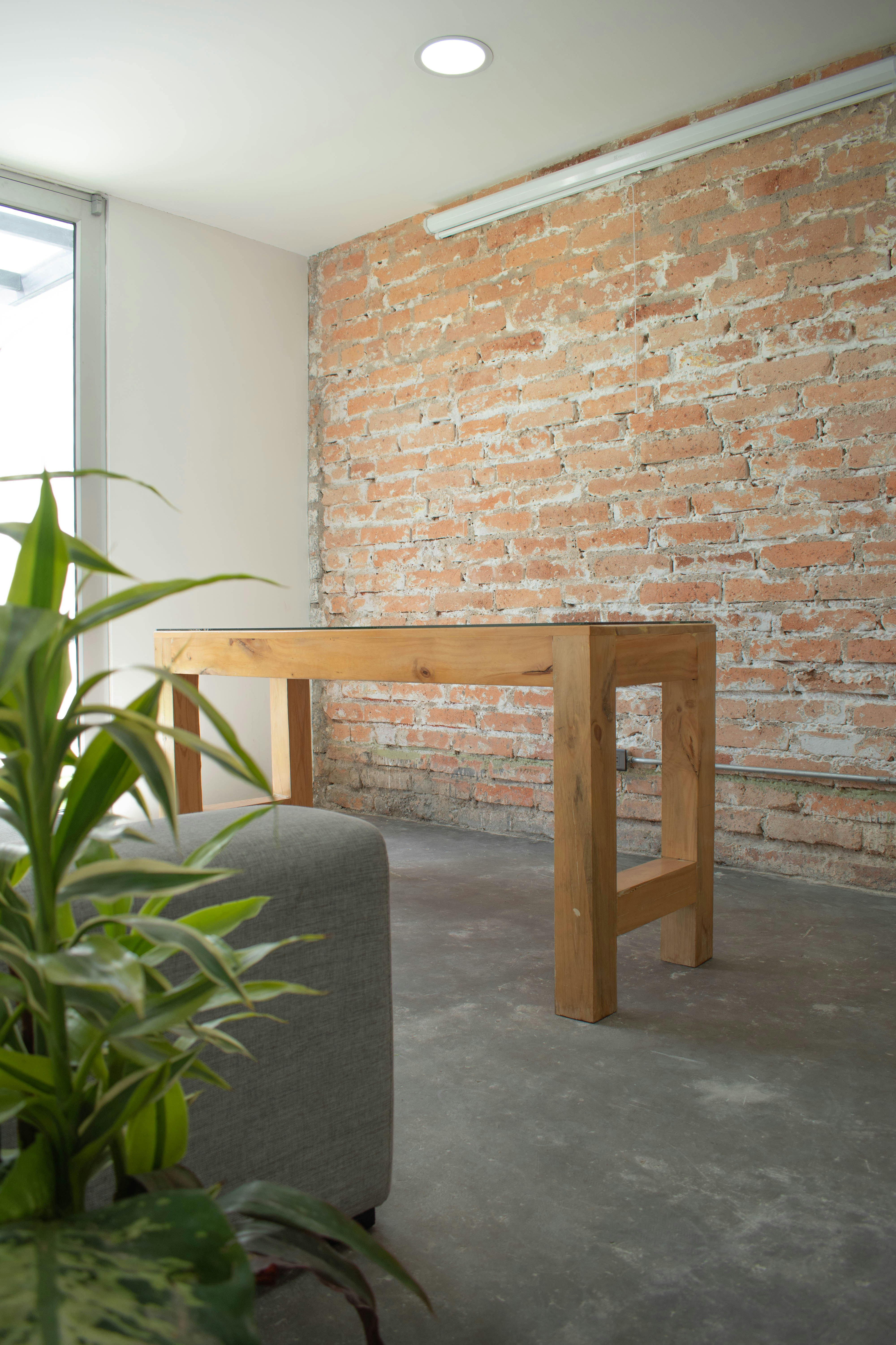 a wooden table sitting in front of a brick wall