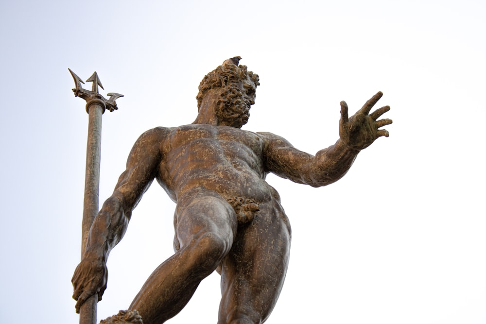 a statue of a man holding a pole