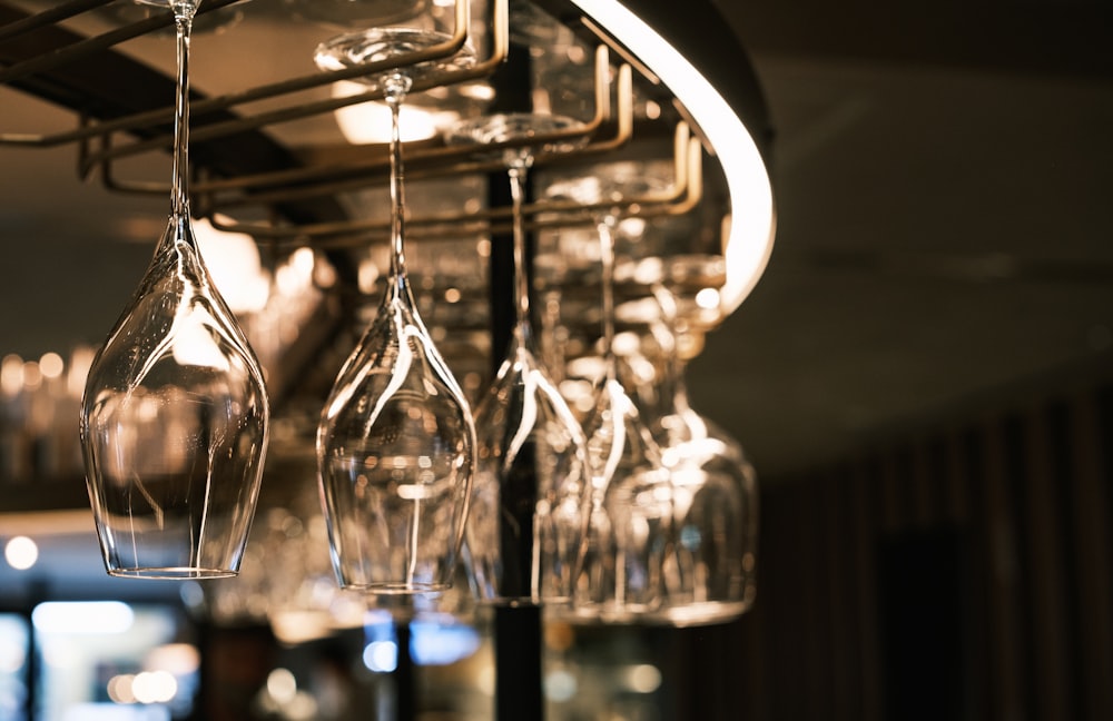 a bunch of wine glasses hanging from a rack