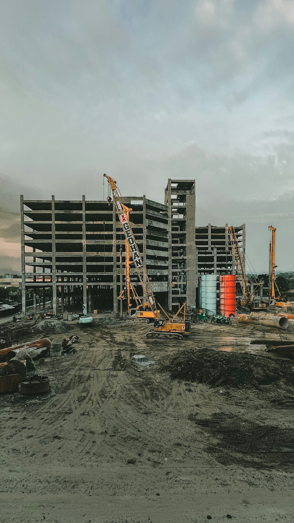 a construction site with a large building in the background
