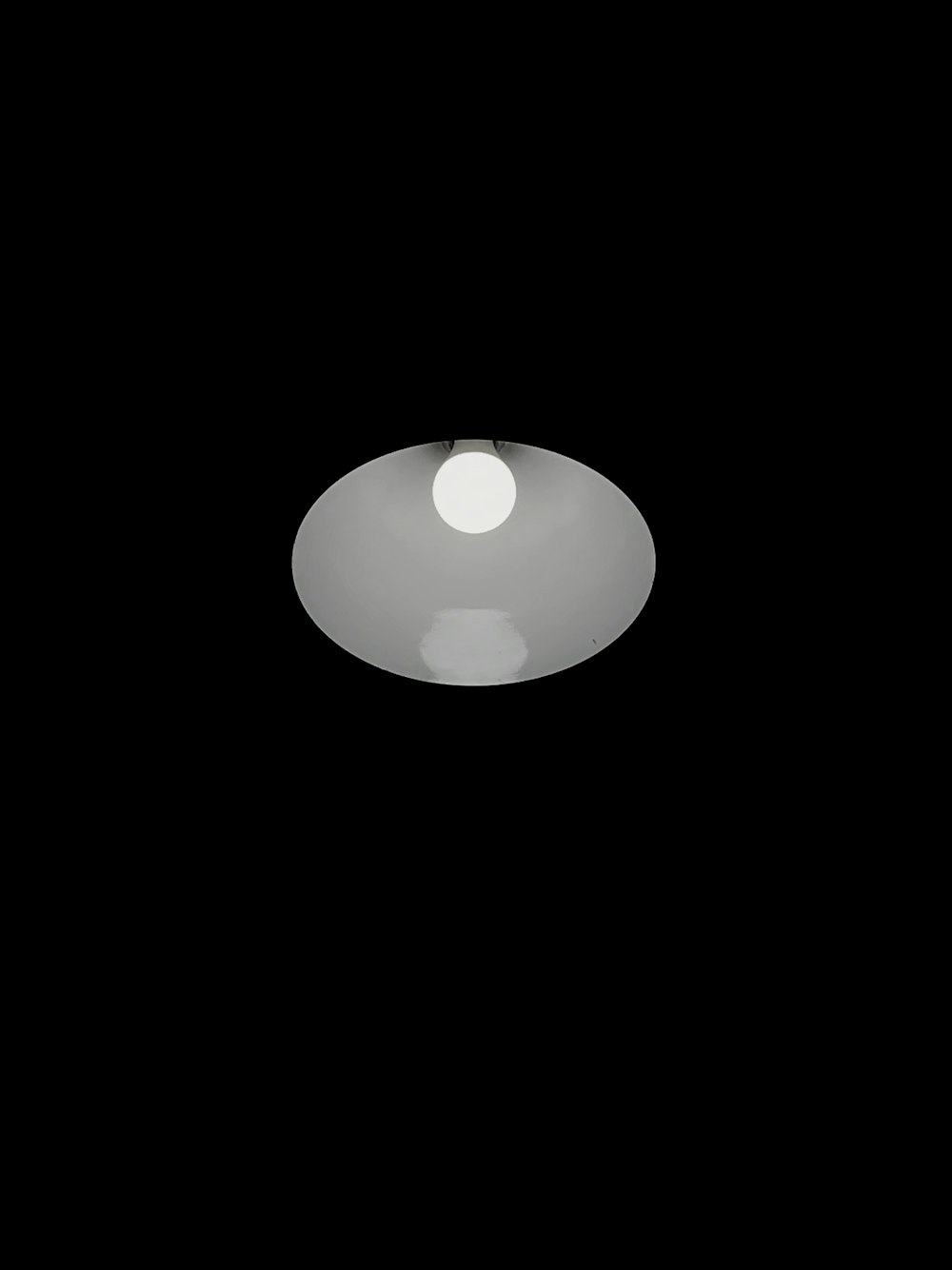 a black and white photo of a light in the dark