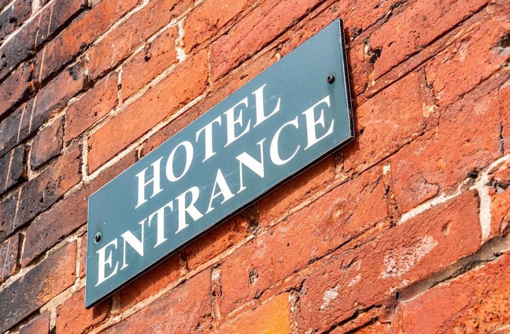 a hotel entrance sign on a brick wall