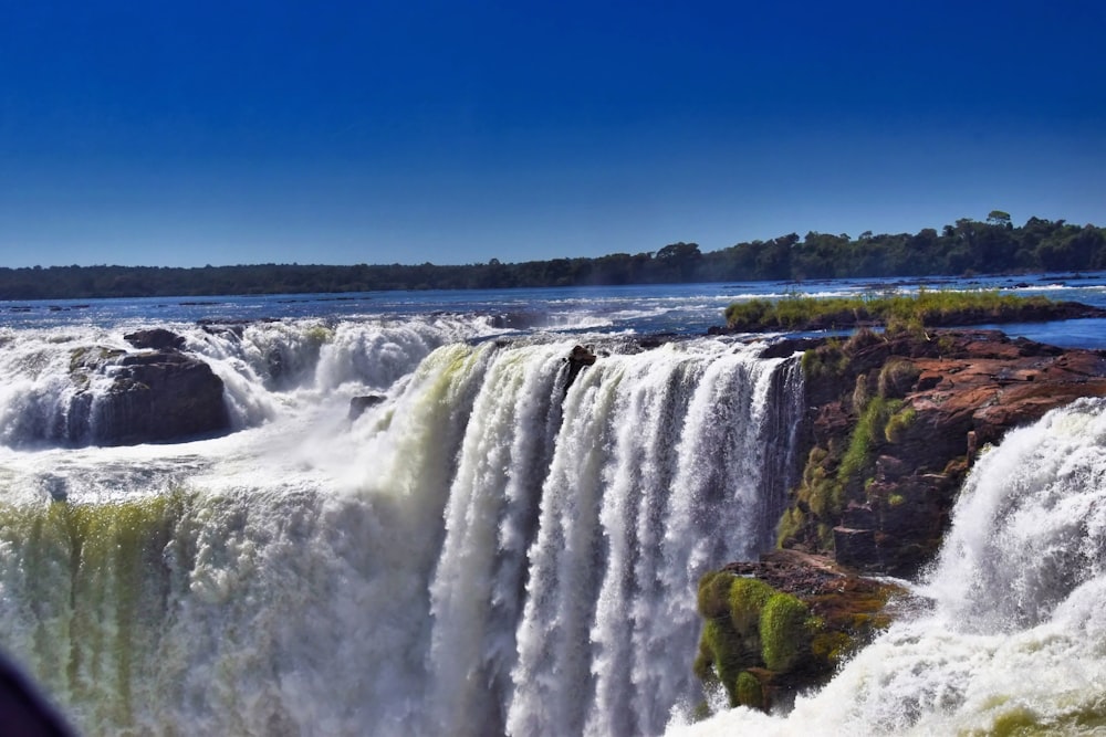 a man taking a picture of a waterfall