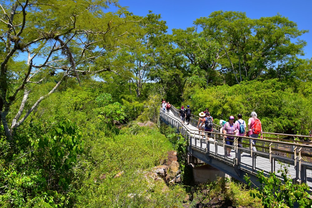 a group of people walking across a bridge