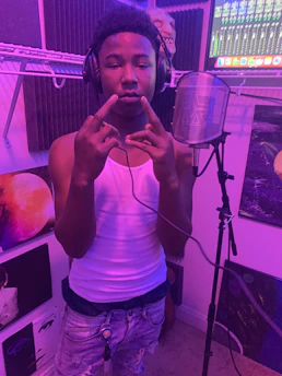 An artist wearing headphones, nodding to a fresh beat in a modern recording studio.