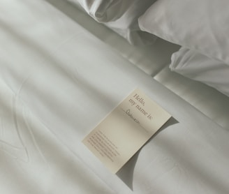 a sheet of paper on a bed with white sheets