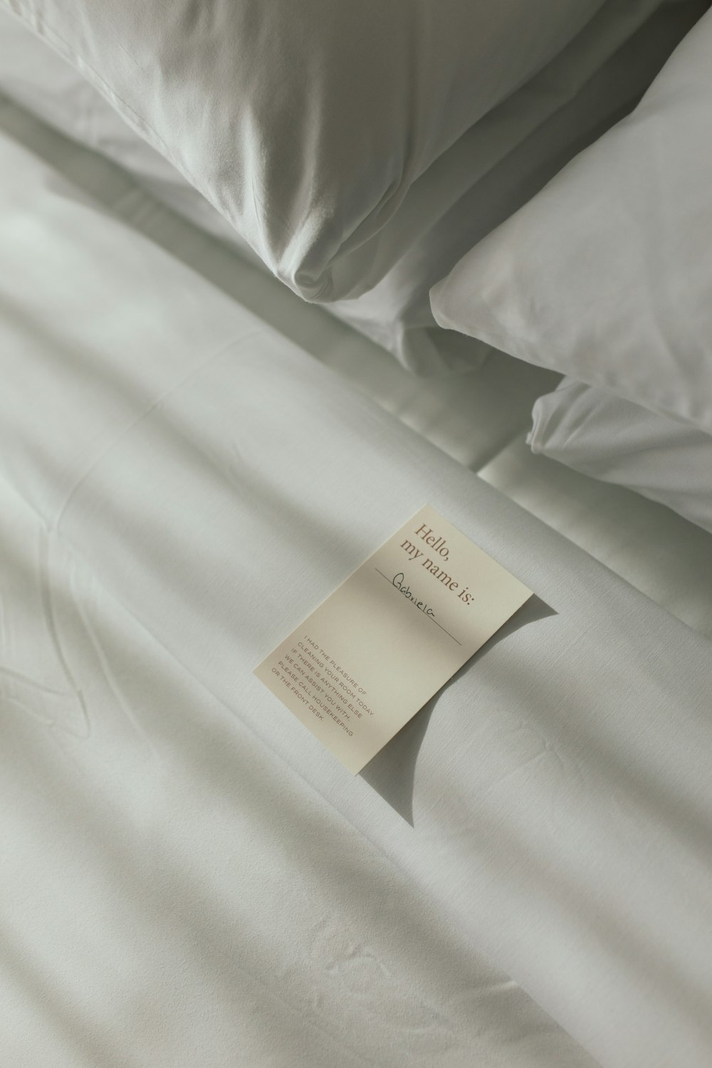 une feuille de papier sur un lit avec des draps blancs