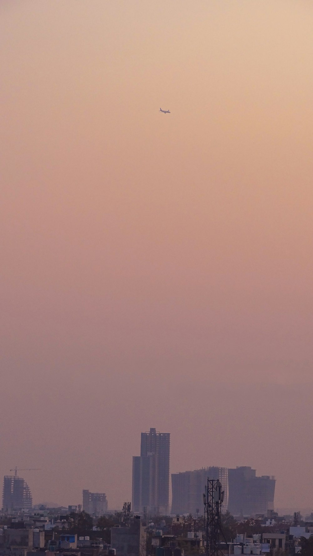 a plane flying over a city with tall buildings